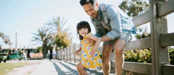 Dad teaches young daughter how to skate board