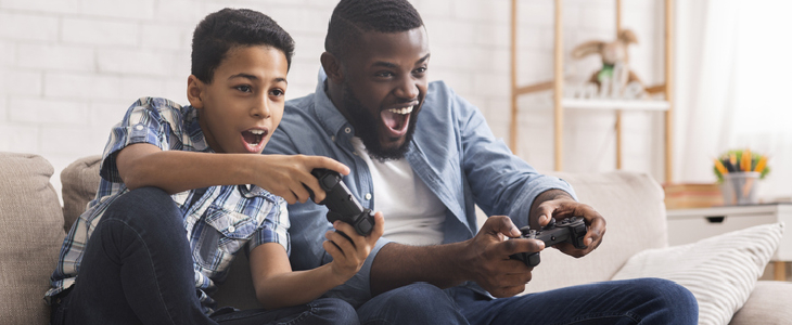 A young father playing video games with his son